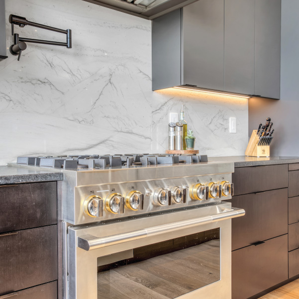 A stainless steel stove in a kitchen with a marble backsplash and mixed color countertops built by Mike Riddle Construction A stainless steel stove in a kitchen with a marble backsplash and mixed color countertops built by Mike Riddle Construction